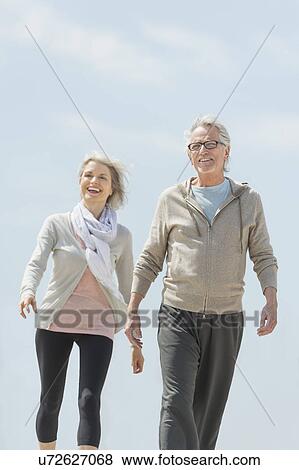 Senior couple walking and holding hands View Large Photo Image Stock Photo - Senior couple walking and holding hands. Fotosearch