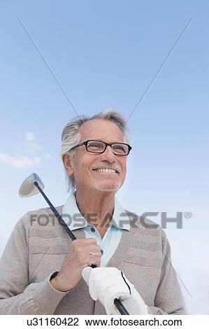 Senior man holding golf club View Large Photo Image Stock Image - Senior man holding golf club. Fotosearch