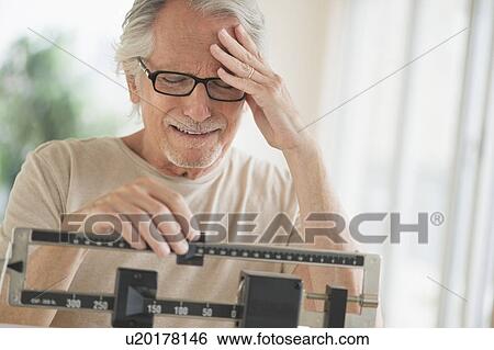 Stock Photograph - Senior man on weight scale. Fotosearch