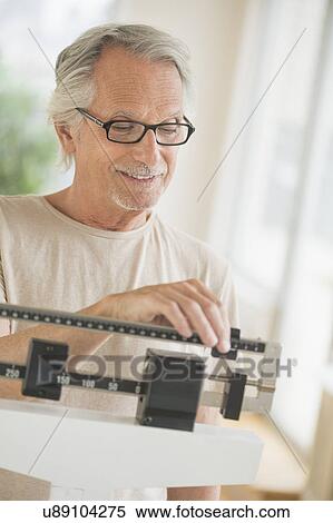 Senior man on weight scale View Large Photo Image Stock Photography - Senior man on weight scale. Fotosearch