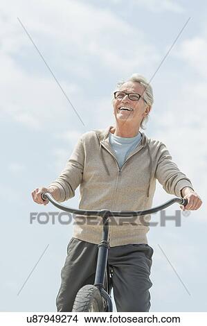 Picture - Senior man riding bicycle. Fotosearch