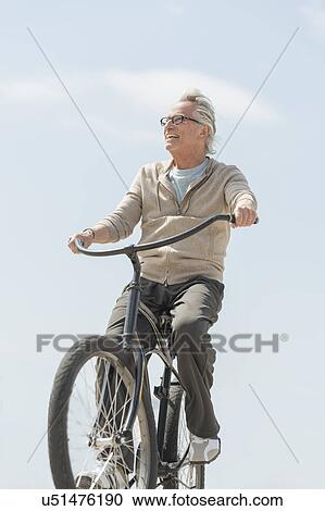 Stock Image - Senior man riding bicycle. Fotosearch