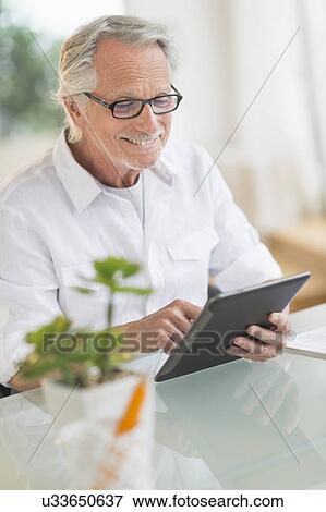 Senior man using digital tablet View Large Photo Image Stock Photo - Senior man using digital tablet. Fotosearch
