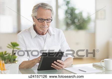 Senior man using digital tablet View Large Photo Image Stock Photograph - Senior man using digital tablet. Fotosearch