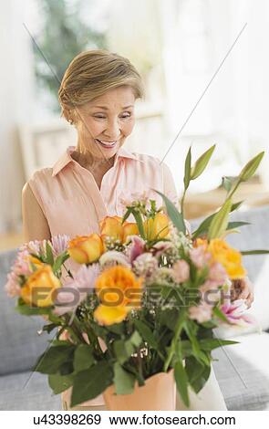 Senior woman arranging flowers at home View Large Photo Image Stock Photo - Senior woman arranging flowers at home. Fotosearch