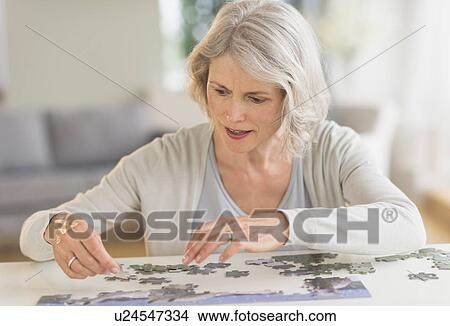 Senior woman completing jigsaw puzzle View Large Photo Image Picture - Senior woman completing jigsaw puzzle. Fotosearch