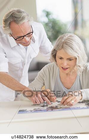 Senior woman completing jigsaw puzzle View Large Photo Image Stock Photo - Senior woman completing jigsaw puzzle. Fotosearch