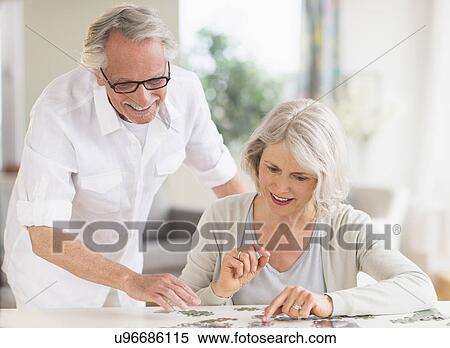 Senior woman completing jigsaw puzzle View Large Photo Image Stock Photography - Senior woman completing jigsaw puzzle. Fotosearch