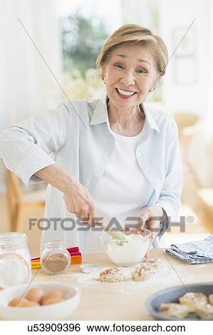 Senior woman cooking in kitchen View Large Photo Image Stock Photograph - Senior woman cooking in kitchen. Fotosearch