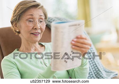 Stock Photo - Senior woman doing crossword puzzle. Fotosearch
