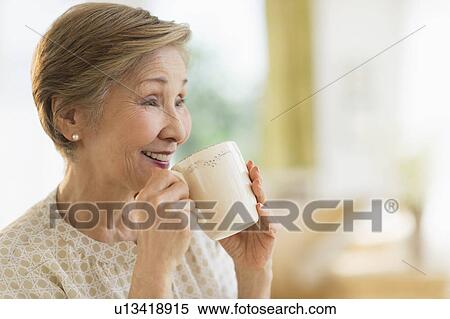 Stock Photography - Senior woman drinking from mug. Fotosearch
