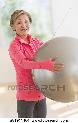 Senior woman exercising with fitness ball View Large Photo Image Picture - Senior woman exercising with fitness ball. Fotosearch
