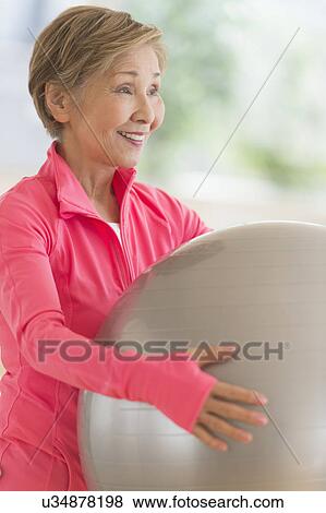 Stock Photo - Senior woman exercising with fitness ball. Fotosearch