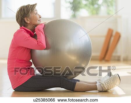 Senior woman exercising with fitness ball View Large Photo Image Stock Photograph - Senior woman exercising with fitness ball. Fotosearch