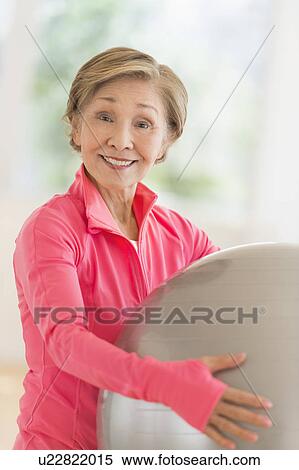 Stock Photography - Senior woman exercising with fitness ball. Fotosearch