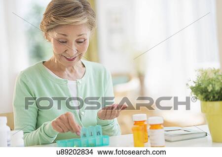 Senior woman organizing medicine in box View Large Photo Image Picture - Senior woman organizing medicine in box. Fotosearch