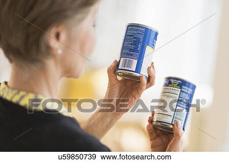 Senior woman reading labels on canned food View Large Photo Image Stock Photo - Senior woman reading labels on canned food. Fotosearch
