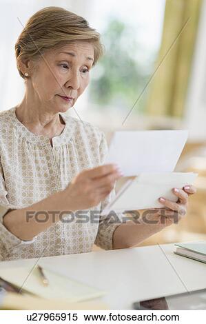 Stock Photography - Senior woman reading letter. Fotosearch