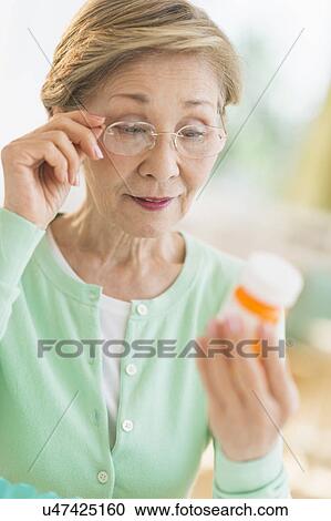 Senior woman reading medicine label View Large Photo Image Stock Image - Senior woman reading medicine label. Fotosearch