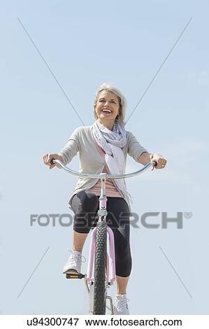 Senior woman riding bicycle View Large Photo Image Stock Photo - Senior woman riding bicycle. Fotosearch
