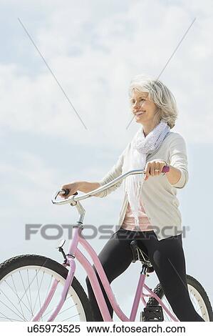 Senior woman riding bicycle View Large Photo Image Stock Photography - Senior woman riding bicycle. Fotosearch