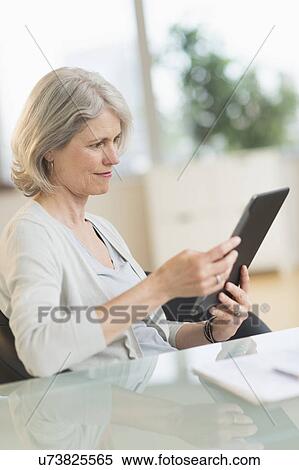 Stock Photography - Senior woman using digital tablet. Fotosearch