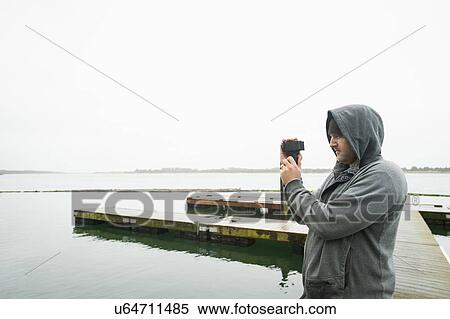 Stock Photography - Side view of man photographing. Fotosearch