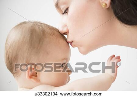 Side view of mother kissing her baby daughter (6-11 months) View Large Photo Image Picture - Side view of mother kissing her baby daughter (6-11 months). Fotosearch