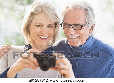 Smiling senior couple with digital camera View Large Photo Image Stock Image - Smiling senior couple with digital camera. Fotosearch