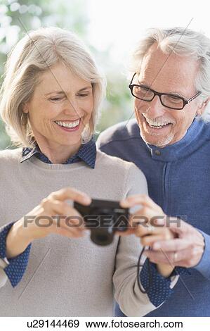 Stock Photo - Smiling senior couple with digital camera. Fotosearch