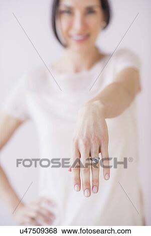 Studio Shot of woman showing her engagement ring View Large Photo Image Stock Photo - Studio Shot of woman showing her engagement ring. Fotosearch