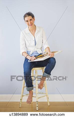 Studio Shot of woman sitting on stool, holding paintbrushes and artist's canvas View Large Photo Image Stock Photo - Studio Shot of woman sitting on stool, holding paintbrushes and artist's canvas. Fotosearch