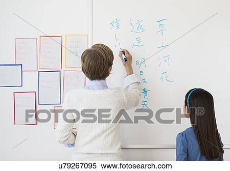 Teacher and schoolgirl (8-9) writing at whiteboard View Large Photo Image Stock Photography - Teacher and schoolgirl (8-9) writing at whiteboard. Fotosearch