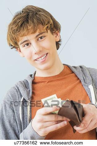 Teenage boy (14-15) counting money and looking at camera View Large Photo Image Stock Image - Teenage boy (14-15) counting money and looking at camera. Fotosearch