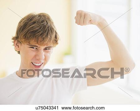 Teenage boy (14-15) flexing muscles View Large Photo Image Stock Image - Teenage boy (14-15) flexing muscles. Fotosearch
