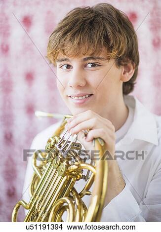 Picture - Teenage boy (14-15) holding french horn. Fotosearch