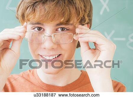 Teenage boy (14-15) in classroom wearing glasses View Large Photo Image Stock Photo - Teenage boy (14-15) in classroom wearing glasses. Fotosearch