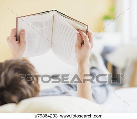 Teenage boy (14-15) lying on bed and reading book View Large Photo Image Stock Image - Teenage boy (14-15) lying on bed and reading book. Fotosearch