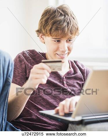 Stock Photography - Teenage boy (14-15) shopping online. Fotosearch