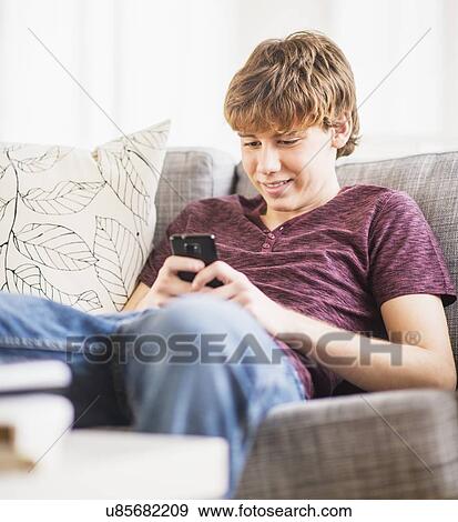 Teenage boy (14-15) sitting and text messaging View Large Photo Image Stock Photo - Teenage boy (14-15) sitting and text messaging. Fotosearch
