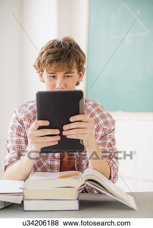 Teenage boy (14-15) sitting in classroom with tablet pc View Large Photo Image Stock Photo - Teenage boy (14-15) sitting in classroom with tablet pc. Fotosearch