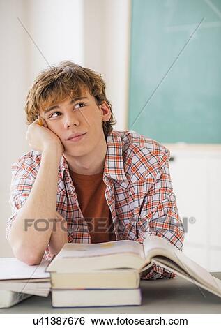 Teenage boy (14-15) sitting in classroom with pencil and books View Large Photo Image Stock Photograph - Teenage boy (14-15) sitting in classroom with pencil and books. Fotosearch