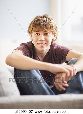 Teenage boy (14-15) sitting on bed and looking at camera View Large Photo Image Stock Photo - Teenage boy (14-15) sitting on bed and looking at camera. Fotosearch