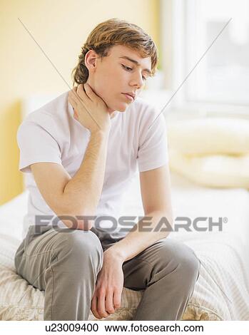 Teenage boy (14-15) sitting on bed View Large Photo Image Stock Image - Teenage boy (14-15) sitting on bed . Fotosearch