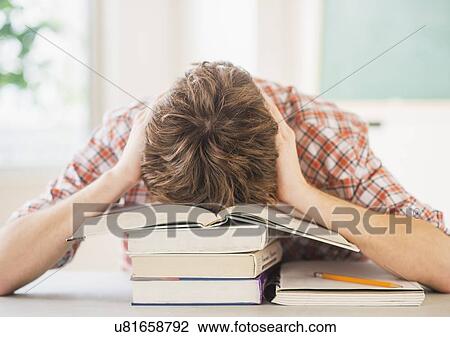 Stock Image - Teenage boy (14-15) sleeping in classroom . Fotosearch