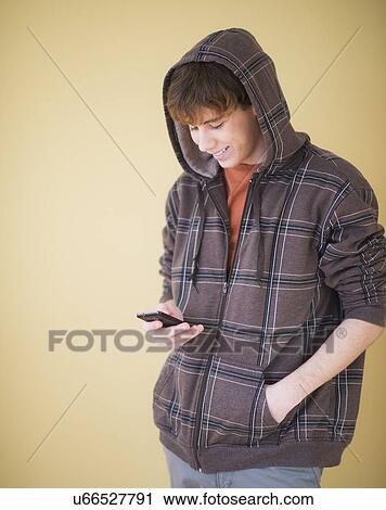 Stock Image - Teenage boy (14-15) text messaging. Fotosearch