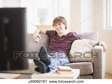 Stock Photo - Teenage boy (14-15) watching tv. Fotosearch