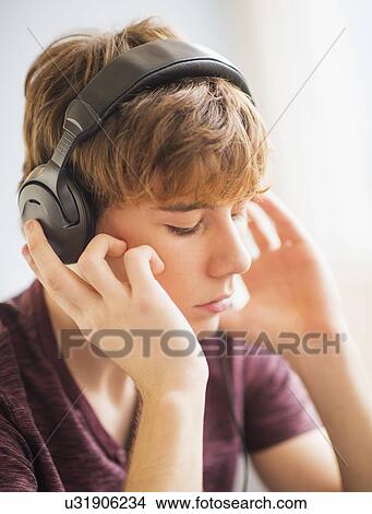 Teenage boy (14-15) wearing headphones View Large Photo Image Picture - Teenage boy (14-15) wearing headphones. Fotosearch