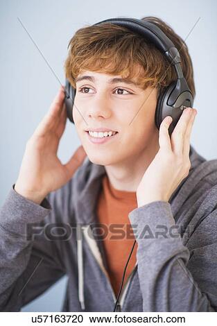 Teenage boy (14-15) wearing headphones and smiling View Large Photo Image Stock Image - Teenage boy (14-15) wearing headphones and smiling. Fotosearch