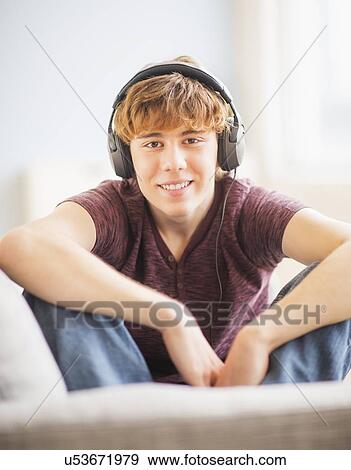 Teenage boy (14-15) wearing headphones and smiling View Large Photo Image Stock Photo - Teenage boy (14-15) wearing headphones and smiling. Fotosearch